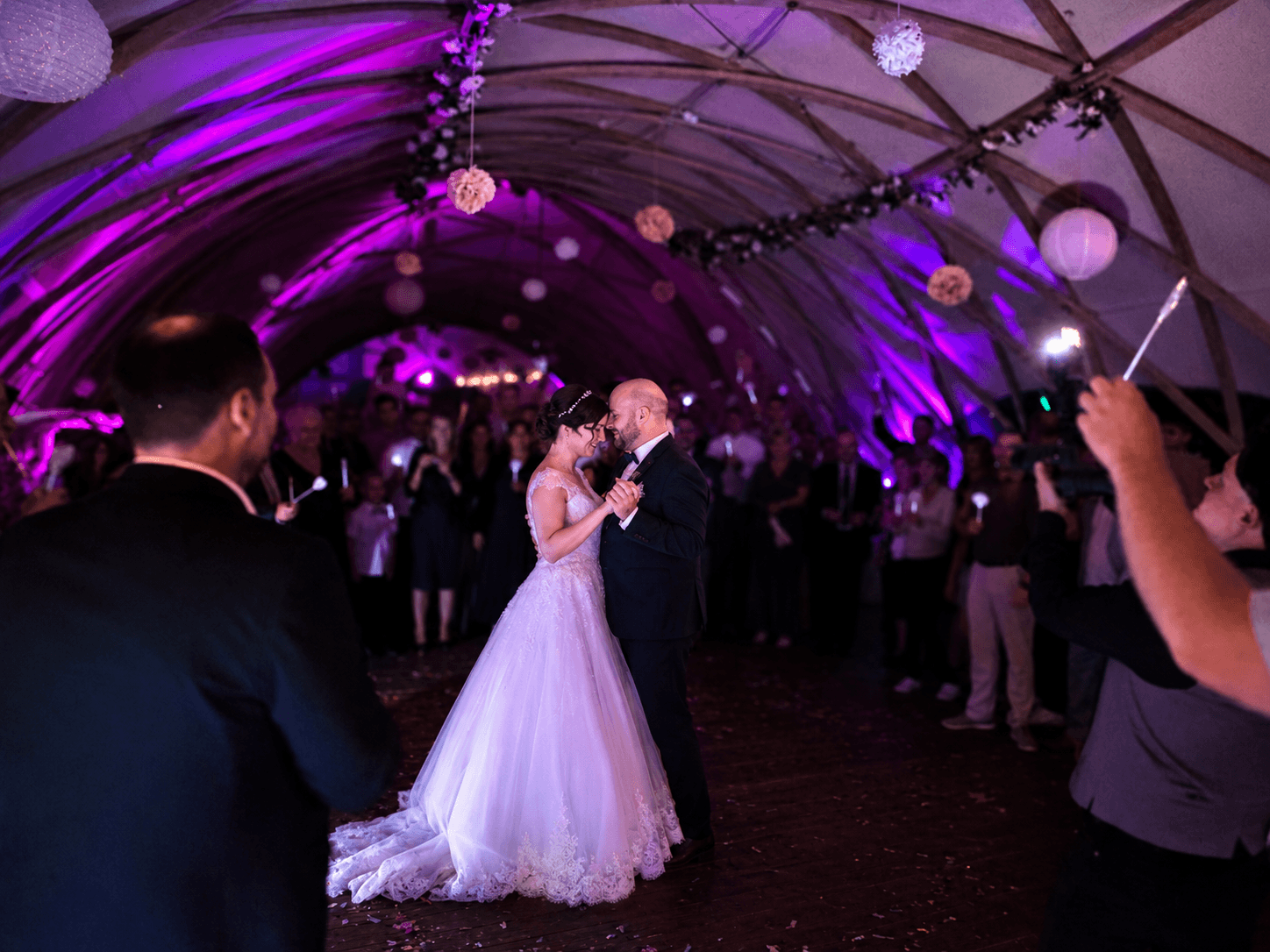 Brautpaar beim Hochzeitstanz in festlich beleuchteter Location